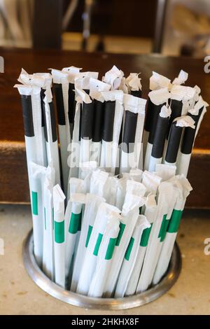 Pailles en plastique avec enveloppeurs en papier dans le comptoir - les pailles que beaucoup d'États et de pays sont hors-loi mais sont encore utilisés beaucoup d'endroits Banque D'Images