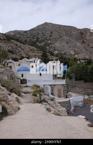 Une belle église orthodoxe attachée aux montagnes de la célèbre plage noire de Kamari Santorini Grèce Banque D'Images