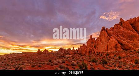 Les nageoires de roche du four Fiery illuminent en rouge par la lumière colorée du coucher du soleil due au feu de Pack Creek, dans le parc national d'Arches, Moab, Utah. Banque D'Images