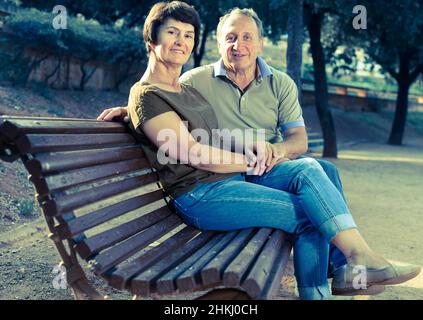 homme et femme âgés qui s'embrassent sur le banc Banque D'Images