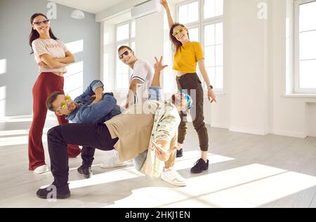 Une équipe de jeunes danseuses gaies s'amuse tout en effectuant des hip-hop ou des pauses dansantes en studio. Banque D'Images