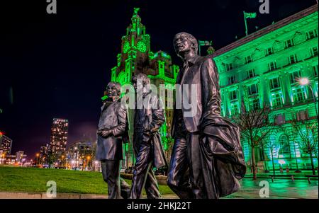 Les Beatles statues en face des bâtiments Royal Liver à Liverpool, Merseyside, qui ont été illuminées en vert pour marquer la Journée mondiale du cancer 2022.Date de la photo : vendredi 4 février 2022. Banque D'Images