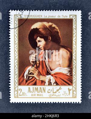 Timbre-poste annulé imprimé par Ajman, qui montre Painting Boy jouant d'un enregistreur par Hendrick Jansz ter Brugghen, vers 1967. Banque D'Images