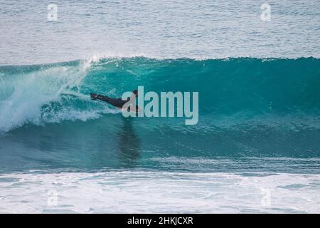 Le surfeur du Bodyboard fait une vague au coucher du soleil. Ericeira Portugal Banque D'Images