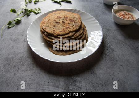 Plat de petit-déjeuner populaire aloo ka paratha ou pain plat farci de pomme de terre dans une assiette blanche. Gros plan. Banque D'Images