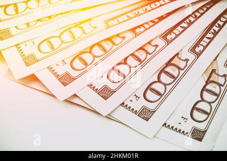 Dispositions échellées de billets américains de 100 dollars.Billets américains de 100 dollars en papier placé sur fond blanc avec soleil Banque D'Images