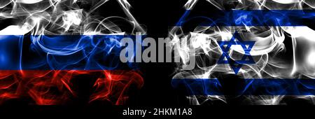 Russie, Russie contre Israël, drapeaux israéliens.Drapeau de fumée placé côte à côte isolé sur fond noir. Banque D'Images