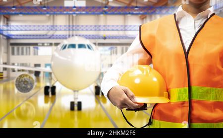 Un ingénieur ou un technicien asiatique travaille avec un avion dans un hangar Banque D'Images