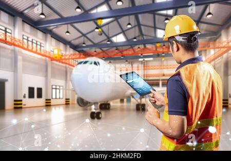 Un ingénieur ou un technicien asiatique travaille avec un avion dans un hangar Banque D'Images