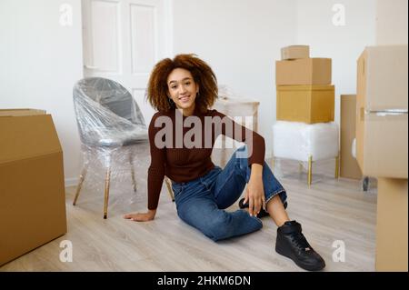 Femme assise parmi des boîtes de carton avec des débuts Banque D'Images