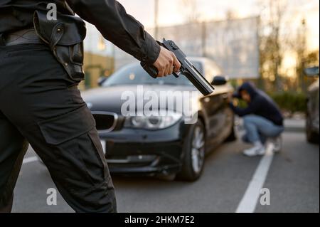 Policier tenant un fusil à la vue du voleur de voiture Banque D'Images