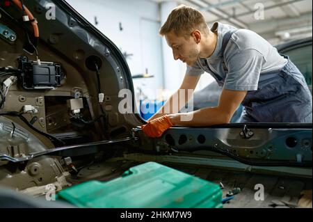 Boulon de fixation de l'homme de travail pendant la réparation de la carrosserie Banque D'Images