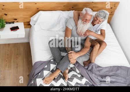 Couple senior heureux ayant des moments tendres dans le lit Banque D'Images