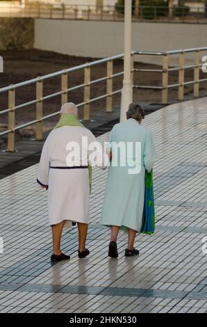 Un couple plus âgé va nager dans la mer.Playa de Arinaga.Aguimes.Grande Canarie.Îles Canaries.Espagne. Banque D'Images