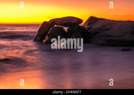 Coucher de soleil sur la plage et affleurement rocheux à Aregno Plage près d'Algajola dans la région de Balagne en Corse Banque D'Images