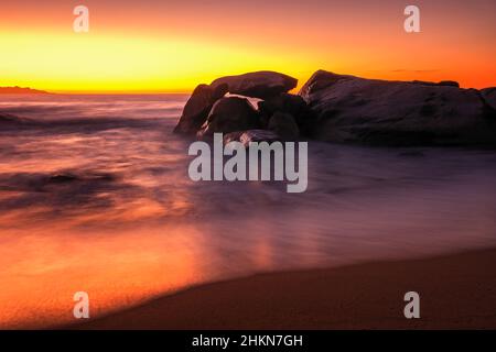 Coucher de soleil sur la plage et affleurement rocheux à Aregno Plage près d'Algajola dans la région de Balagne en Corse Banque D'Images