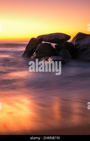 Coucher de soleil sur la plage et affleurement rocheux à Aregno Plage près d'Algajola dans la région de Balagne en Corse Banque D'Images