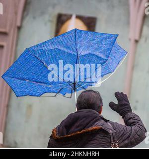 Parapluie bleu soufflé à l'intérieur à Preston, dans le Lancashire. Météo Royaume-Uni. 2022 janvier, vents forts et fortes pluies dans le centre-ville, avec des averses de pluie torrentielles et de pluie soufflant de l'ouest. Crédit; MediaWorldImages/AlamyLiveNews Banque D'Images