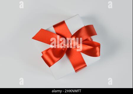 Noël ou toute maquette de vacances boîte cadeau enveloppée dans du papier et avec un noeud rouge isolé sur fond blanc Banque D'Images
