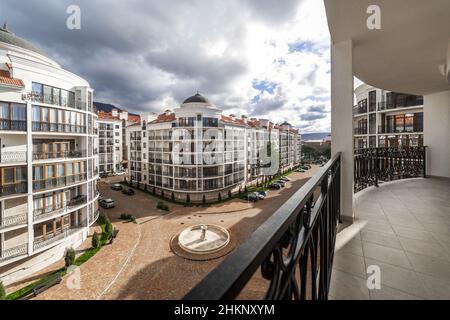 Un grand balcon incurvé d'un bâtiment de plusieurs étages avec des rails en métal noir en fer forgé avec des motifs.Le balcon offre une vue sur les maisons du Banque D'Images