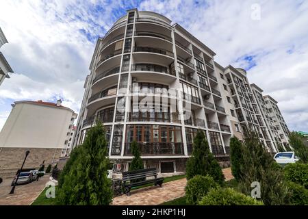 Un grand balcon incurvé d'un bâtiment de plusieurs étages avec des rails en métal noir en fer forgé avec des motifs.Le balcon offre une vue sur les maisons du Banque D'Images