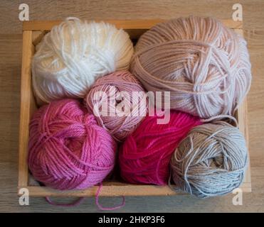 balles de laine colorées dans une boîte en bois pour tricoter ou crochet fait à la main Banque D'Images