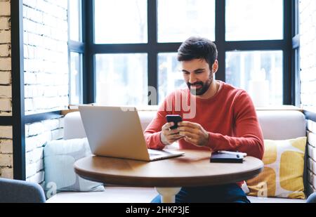 Calme homme utilisant des gadgets dans le café Banque D'Images