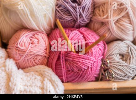 balles de laine colorées dans une boîte en bois avec aiguilles en bambou à tricoter faites à la main Banque D'Images
