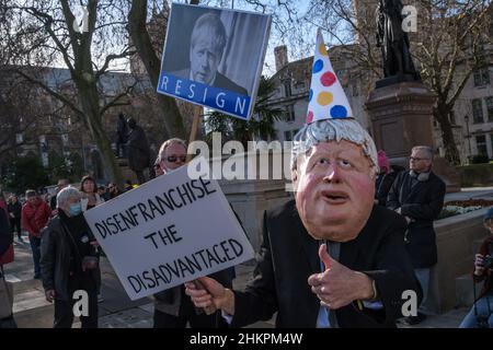 Londres, Royaume-Uni.5th févr. 2022.« Boris Johnson » et homme avec étiquette « démissionnez ».Les militants se rallient au projet de loi actuel sur les élections qui exigerait une pièce d'identité avec photo pour voter et dépénder des millions de personnes sur la place du Parlement.Elle mettrait fin à la coopération des partis dans les sièges, ferait des militants qui manipulent des documents de vote postal une infraction pénale, modifierait le vote par procuration, menacerait l'indépendance de la Commission électorale et remplacerait le vote proportionnel en Mayoral et dans d'autres élections par le système de la première partie du poste discrédité.Peter Marshall/Alay Live News. Banque D'Images