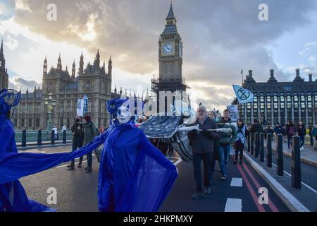 Londres, Royaume-Uni 4th février 2022.Les manifestants portent la « baleine » sur le pont de Westminster.Les activistes ont défilé avec une baleine modèle de la place du Parlement jusqu'au siège de Shell à Londres pour protester contre la destruction des océans et de la faune océanique causée par la fracturation hydraulique, les forages, les levés sismiques et la pollution par les compagnies pétrolières. Banque D'Images