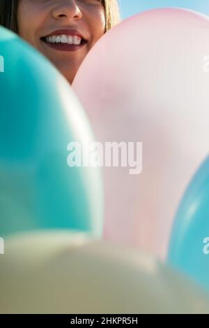 Femme anonyme couvrant son visage avec des ballons Banque D'Images