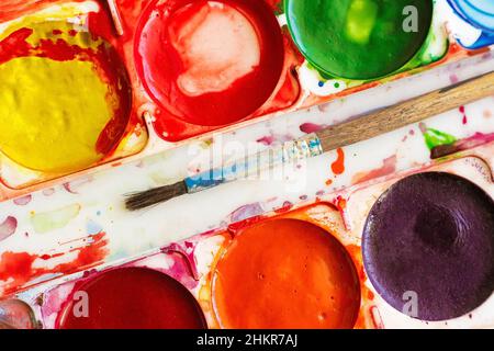palette vieilles peintures aquarelles colorées et pinceau, isolé Banque D'Images