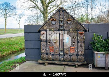 Insecte hôtel dans la cour d'une ferme. Grande structure en bois avec beaucoup de trous, appelé un hôtel d'insectes, également connu comme un hôtel d'insectes ou une maison d'insectes. Banque D'Images