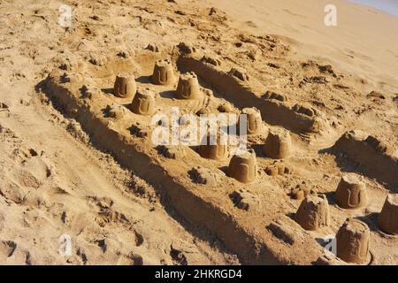 Marche à pied, château de sable et forteresse sur une plage de sable en été Banque D'Images