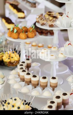 De beaux desserts dans des tasses en plastique, joliment décorées, bar à bonbons, desserts pour un banquet Banque D'Images