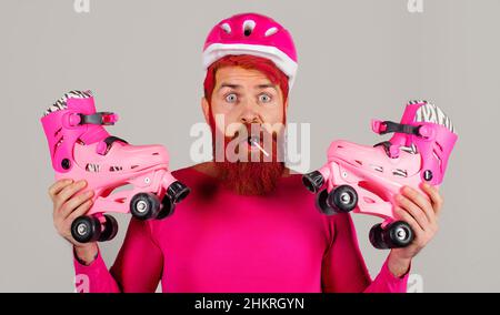 Surpris homme barbu avec des patins à roulettes et un casque.Sport actif.Un mode de vie sain. Banque D'Images