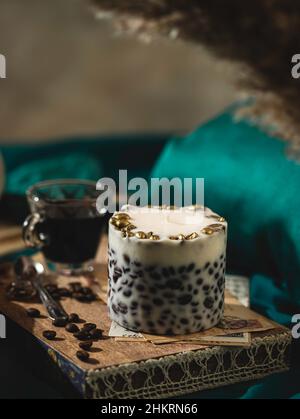 Un plateau en bois avec une bougie et du café parfumés sur le lit.Concept d'hygge.Atmosphère de détente.Style de vie luxueux.Mise au point sélective Banque D'Images
