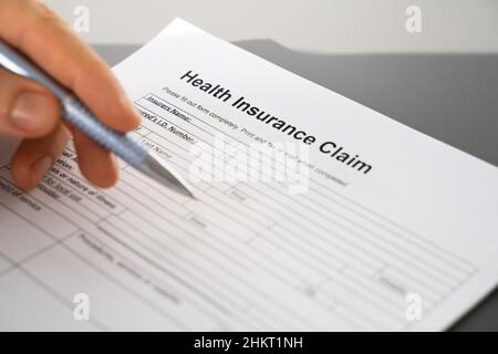 Remplir à la main le formulaire de demande d'assurance maladie.Gros plan Banque D'Images