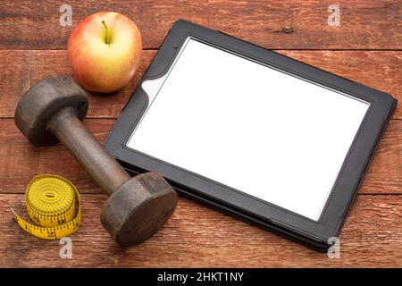 maquette de tablette numérique avec un écran vierge isolé (chemin d'écrêtage inclus), plat avec une haltère, pomme, et mètre ruban, fitness et santé Banque D'Images