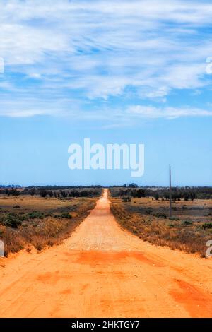 Route en terre battue isolée et non scellée sur la route nationale du lac Mungo dans l'Outback de l'australie lors d'une chaude journée d'été. Banque D'Images