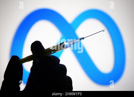 Ukraine.5th févr. 2022.Dans cette illustration, le logo de Meta Platforms est visible sur un écran d'ordinateur et une main tenant une seringue médicale devant lui.(Credit image: © Pavlo Gonchar/SOPA Images via ZUMA Press Wire) Banque D'Images