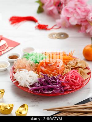 Délicieux et coloré exposition de la cuisine chinoise de prospérité, Yee sang ou Prosperity Toss.Bandes de carottes, chou pourpre, saumon cru, arachides moulées, Banque D'Images