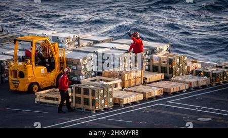 220204-N-OL632-1220 OCÉAN ATLANTIQUE (FÉV4 2022) marins à bord du porte-avions USS George H.W.Bush (CVN 77) déplacer les munitions et les munitions reçues du navire de cargaison et de munitions USNS Medgar Evers (T-AKE 13) sur le pont de vol pendant une charge de munitions, le 4 février 2022.George H.W.Bush fournit à l'autorité de commandement nationale une capacité de combat flexible et tailleurs par le biais du groupe de grève des transporteurs qui maintient la stabilité et la sécurité maritimes afin d'assurer l'accès, de décourager l'agression et de défendre les intérêts américains, alliés et partenaires.(É.-U.Navy photo par Mass communication Speci Banque D'Images