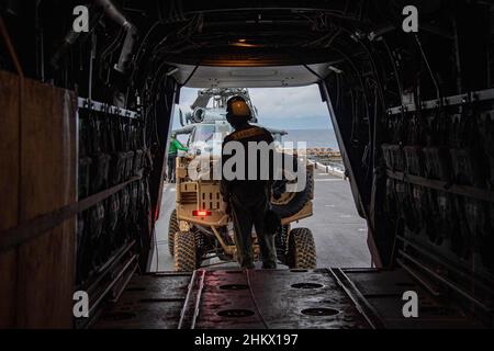 MER DES PHILIPPINES (fév4, 2022)le Caporal Justin Breslin, du comté d'Orange, en Californie, affecté à l'unité expéditionnaire maritime (MEU) de 31st, charge un véhicule utilitaire sur un avion MV-22B Osprey tiltrotor du MEU de 31st sur le pont de vol du navire d'assaut amphibie déployé par l'avant USS America (LHA 6) lors de l'exercice conjoint Fusion Noble.Noble Fusion démontre que les forces expéditionnaires navales déployées à l'avant de la Marine et du corps des Marines peuvent rapidement regrouper en mer les équipes de l'unité expéditionnaire maritime/du groupe de préparation amphibie, ainsi qu'un groupe de grève des transporteurs, ainsi que d'autres équipes conjointes Banque D'Images