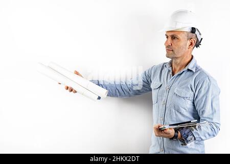 Un ingénieur civil d'âge moyen avec des plans dans ses mains et portant un casque blanc.Portrait isolé sur fond blanc.PH. Stock mâle Banque D'Images