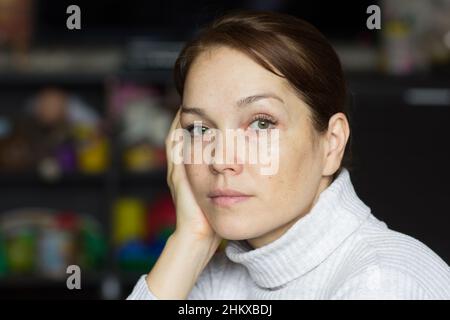 Portrait d'une femme de race blanche d'âge moyen avec un aspect calme tenant sa joue à la main Banque D'Images
