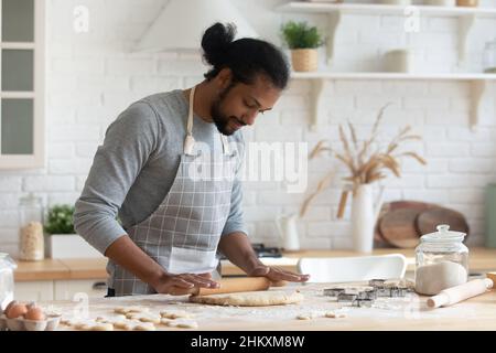 Heureux 30s Afro-américains homme appréciant la cuisine seule à la maison. Banque D'Images
