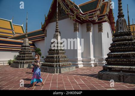 Bangkok, Thaïlande.05th févr. 2022.Un touriste portant un masque facial comme précaution contre la propagation du covid-19 vu marcher à côté d'une pagode au Temple du Bouddha couché.le gouvernement thaïlandais a repris le programme "Test and Go" le 1 février,2022 accueillir les visiteurs entièrement vaccinés de tous les pays avec des mesures supplémentaires de lutte contre la maladie visant à stimuler l'industrie du tourisme et son économie dans le contexte de la propagation continue de la variante Omicron de Covid-19.Crédit : SOPA Images Limited/Alamy Live News Banque D'Images