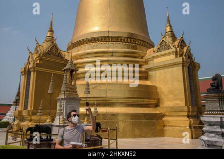 Bangkok, Thaïlande.05th févr. 2022.Un touriste portant un masque facial comme précaution contre la propagation du covid-19 vu prendre des photos au Temple du Bouddha d'Émeraude.le gouvernement thaïlandais a repris le programme "Test and Go" le 1 février,2022 accueillir les visiteurs entièrement vaccinés de tous les pays avec des mesures supplémentaires de lutte contre la maladie visant à stimuler l'industrie du tourisme et son économie dans le contexte de la propagation continue de la variante Omicron de Covid-19.Crédit : SOPA Images Limited/Alamy Live News Banque D'Images