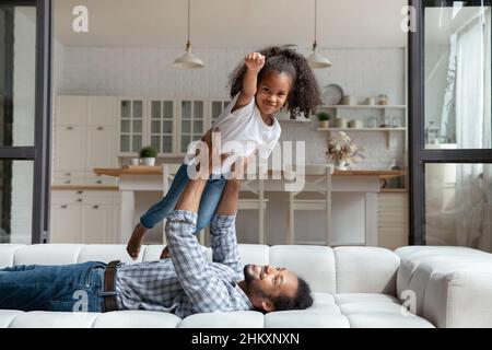 Bonne petite fille africaine s'amusant avec un père attentionné. Banque D'Images